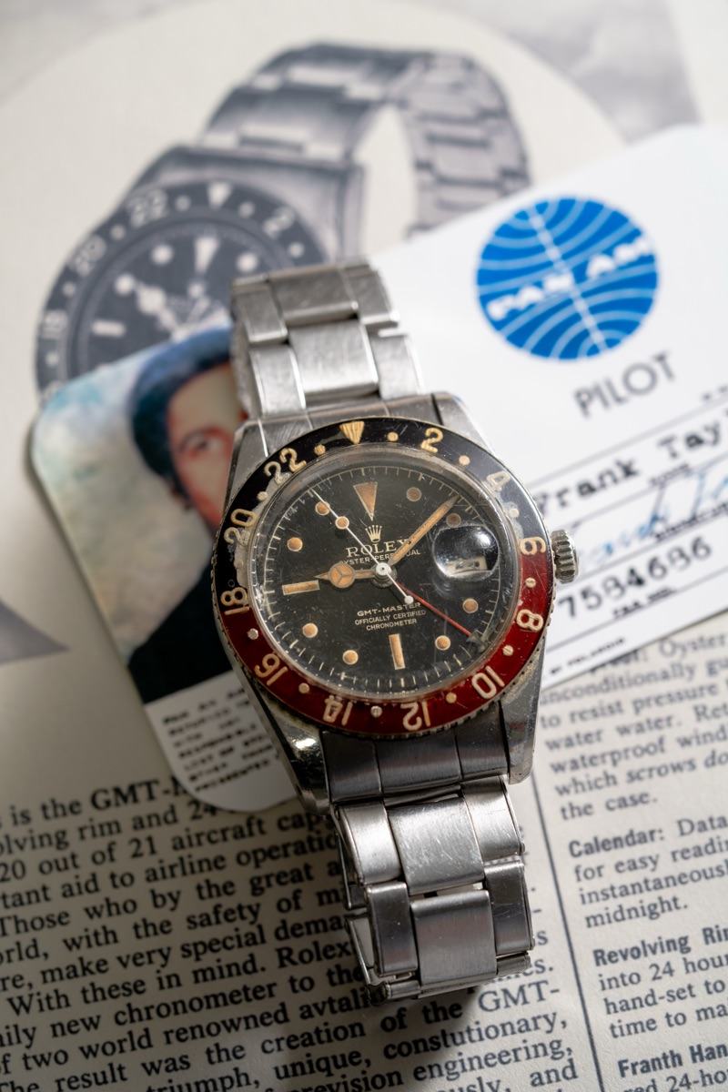 Rolex GMT-Master 6542 à lunette bakélite posée sur des documents de pilote Pan Am