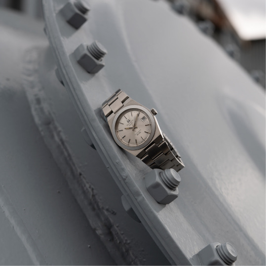 Tissot PR-516 réf. 44919 au cadran argenté, posée sur une pièce d'acier usinée